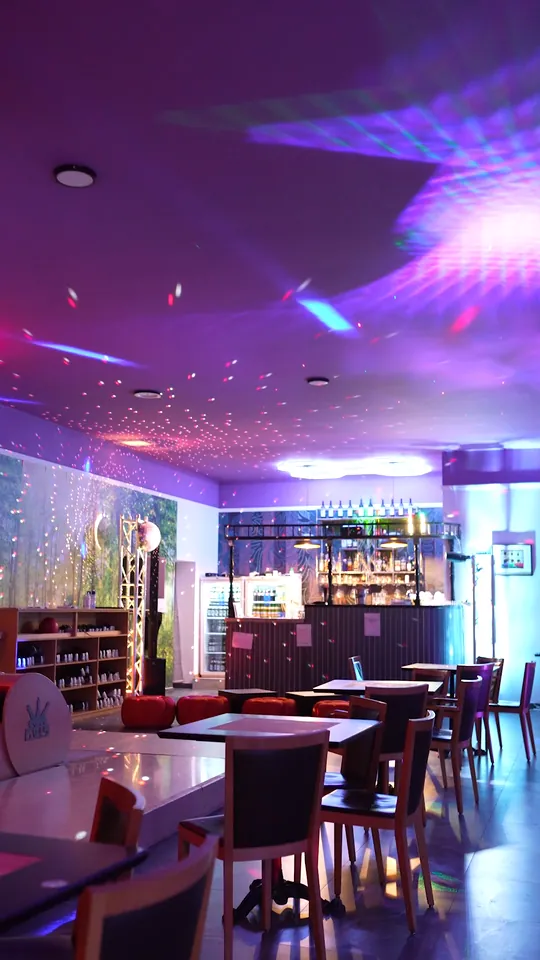 Sala Americanos Bowling cu lumini de petrecere, mese, pistele și barul în fund