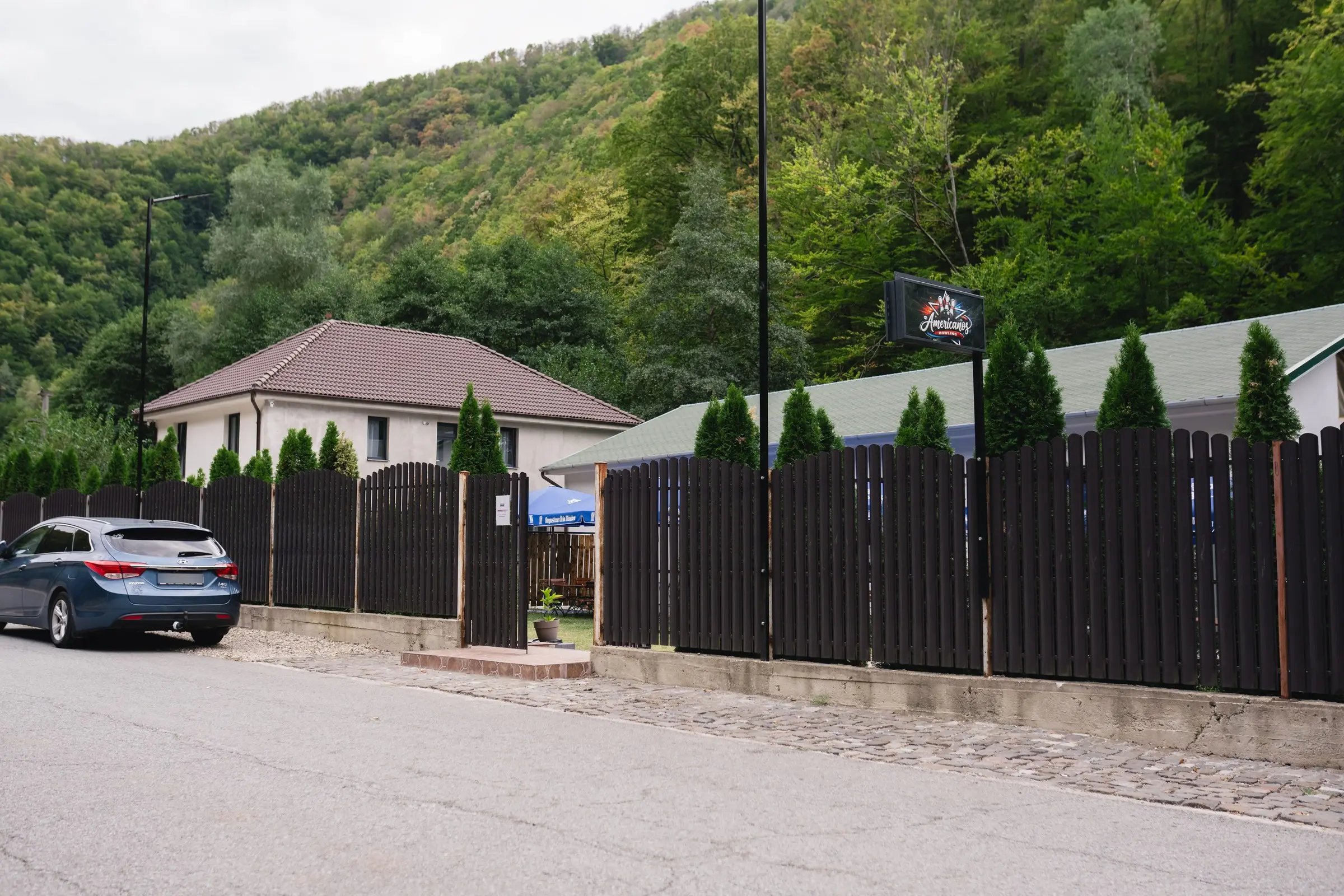 Strada, gardul și firma localului