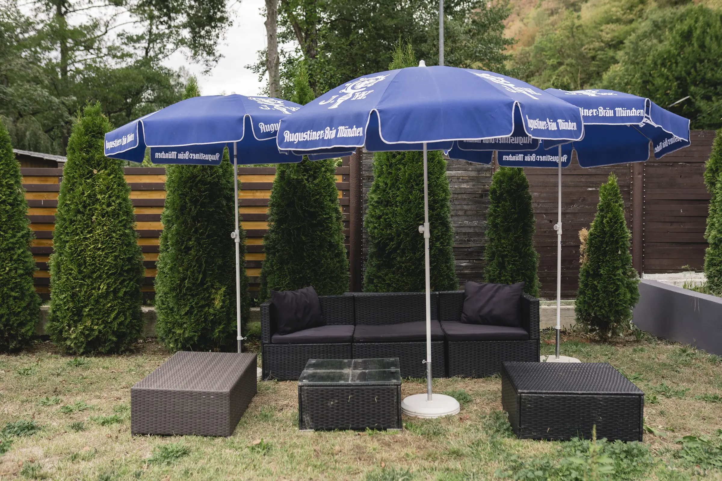 Colțul lounge al terasei, cu canapele sub umbrele